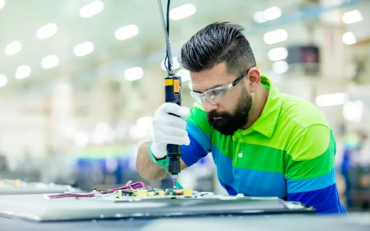 Engineer assembling electronics on a factory floor
