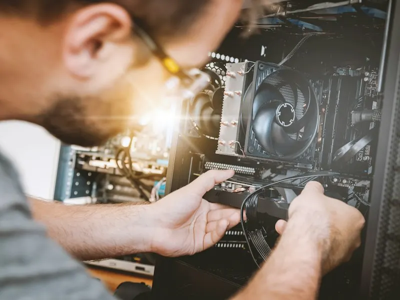 Technician working inside a computer at a client site